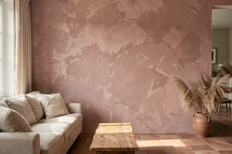 Salon moderne avec mur en peinture à la chaux rose poudré, canapé en lin et sol en tomettes